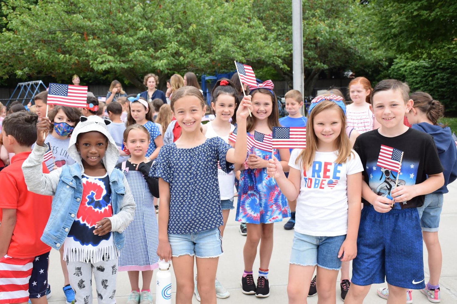 Sylvan Avenue Elementary School students raise their flags during a Flag Day celebration on June 14.
